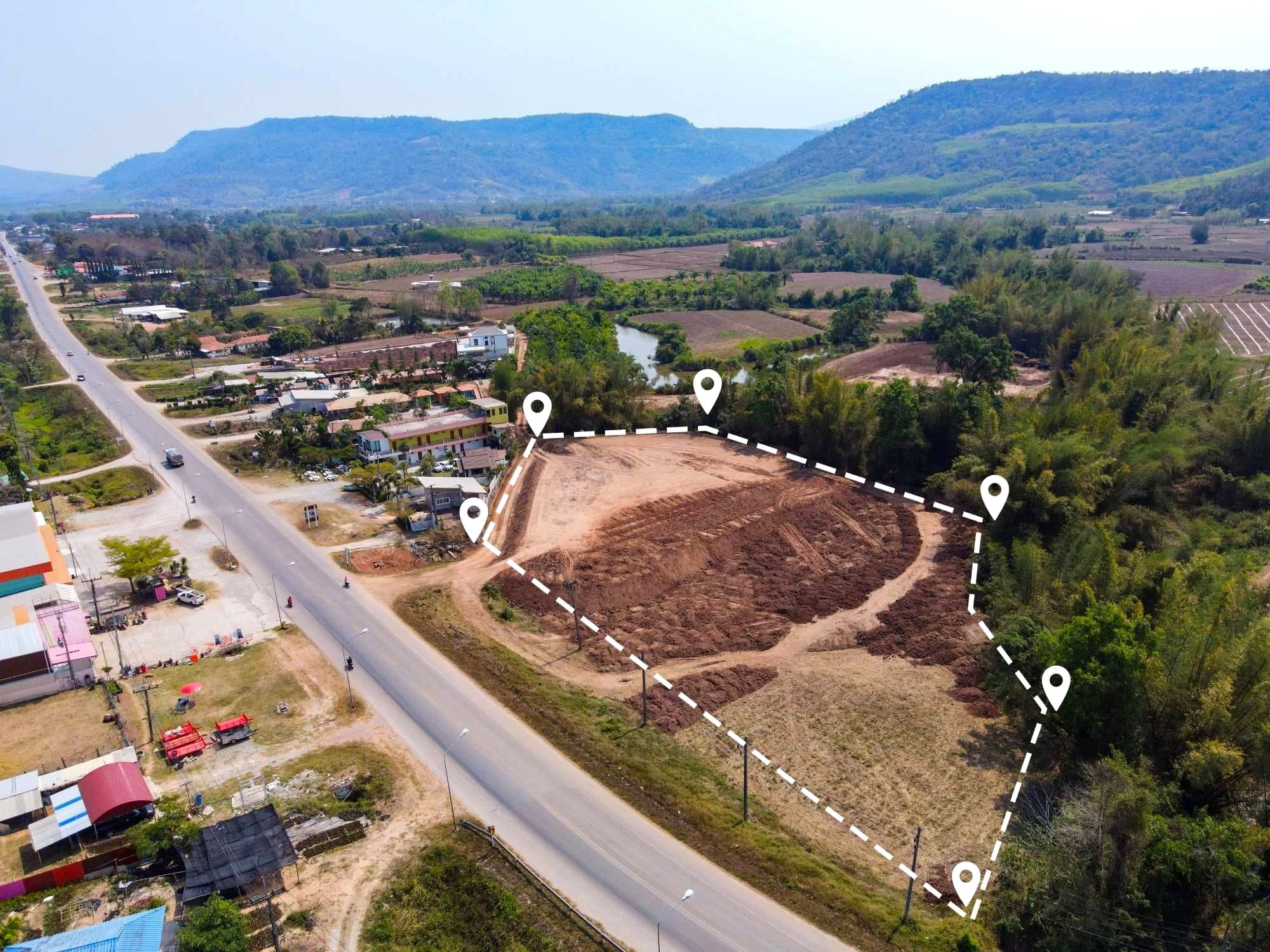 Aerial view of a cleared development plot outlined beside a main road